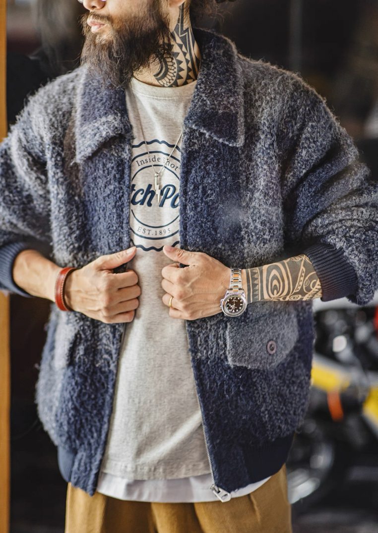 Close-up of model zipping blue-gray boucle plaid jacket.