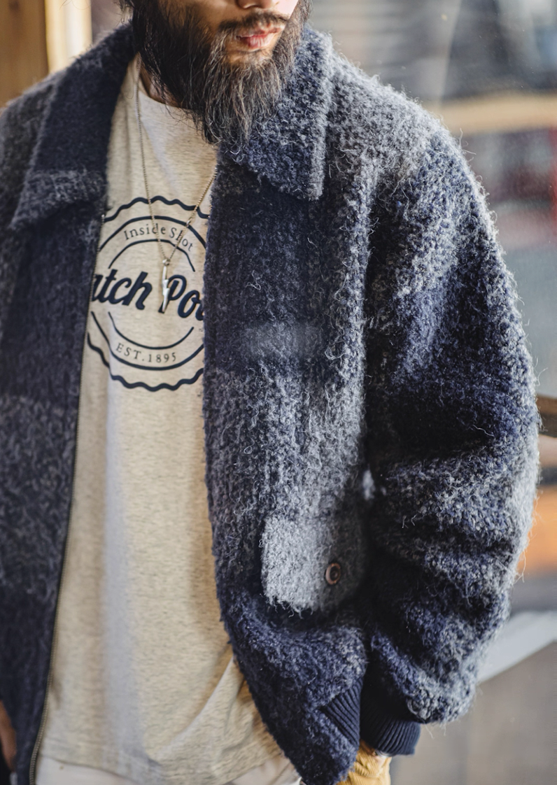 Side view of model in navy gray plaid boucle jacket.