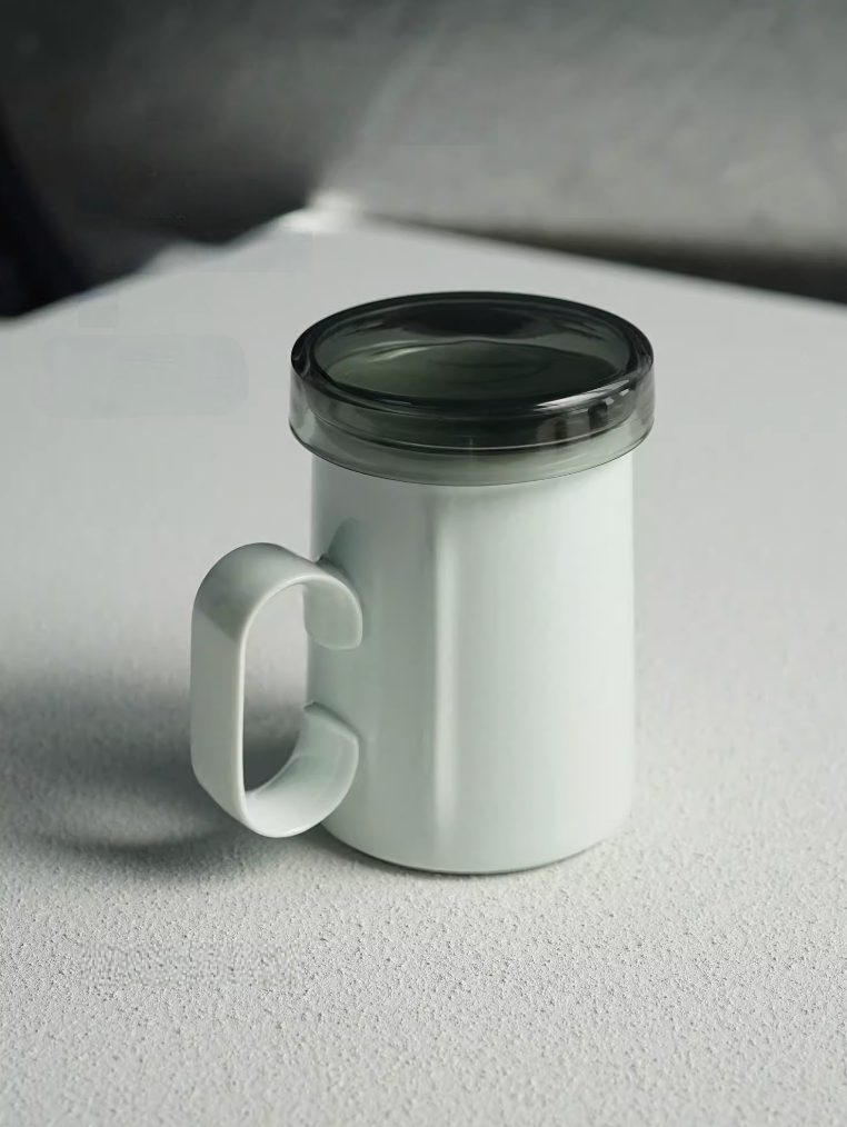 Light Green ring-handle ceramic tea mug with lid, front view showing minimalist shape and translucent lid design
