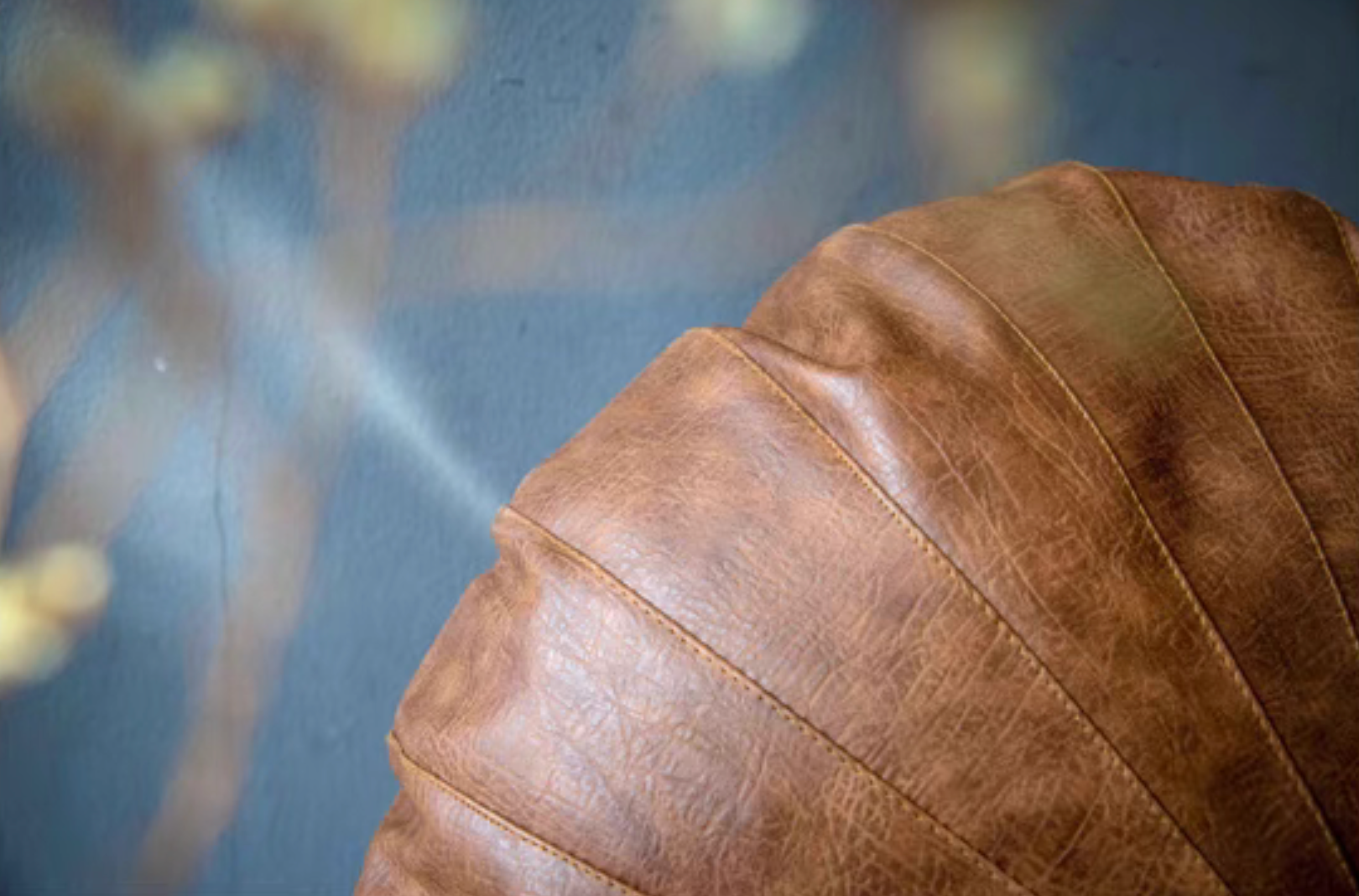 Close-up of camel Scandinavian round floor cushion showing faux leather texture and stitching details