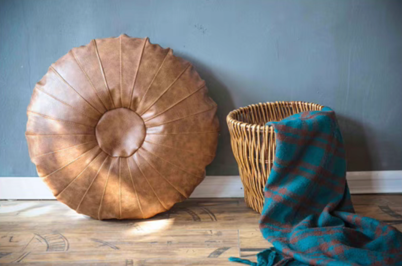 Camel Scandinavian round floor cushion standing upright against wall on wooden floor