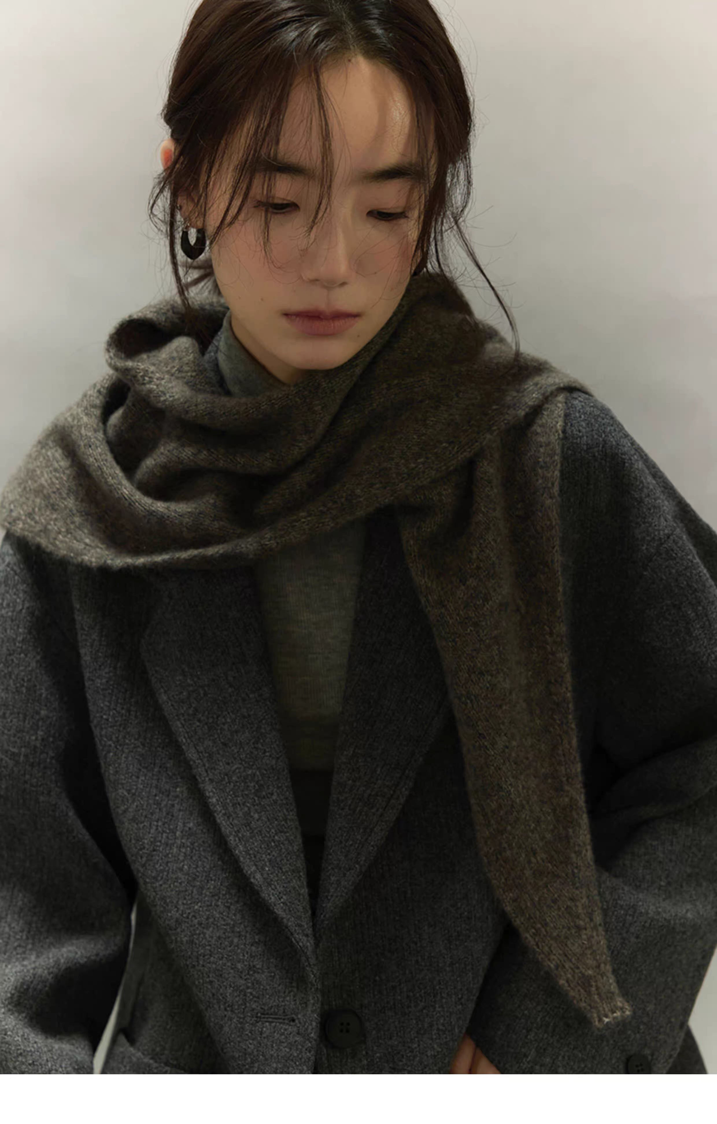 woman wearing charcoal brown scarf layered over grey wool coat