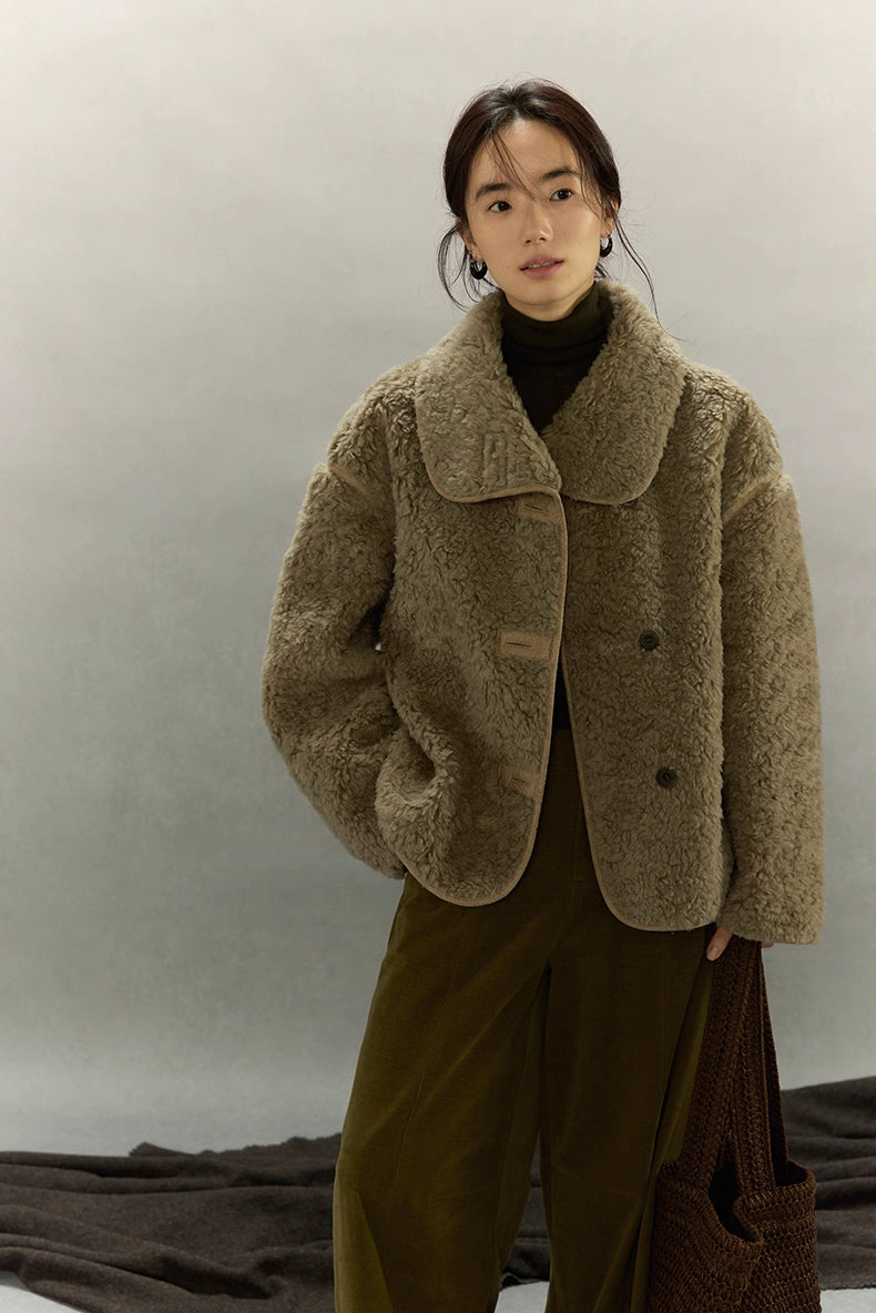 Front view of short sherpa wool jacket with hands in pocket