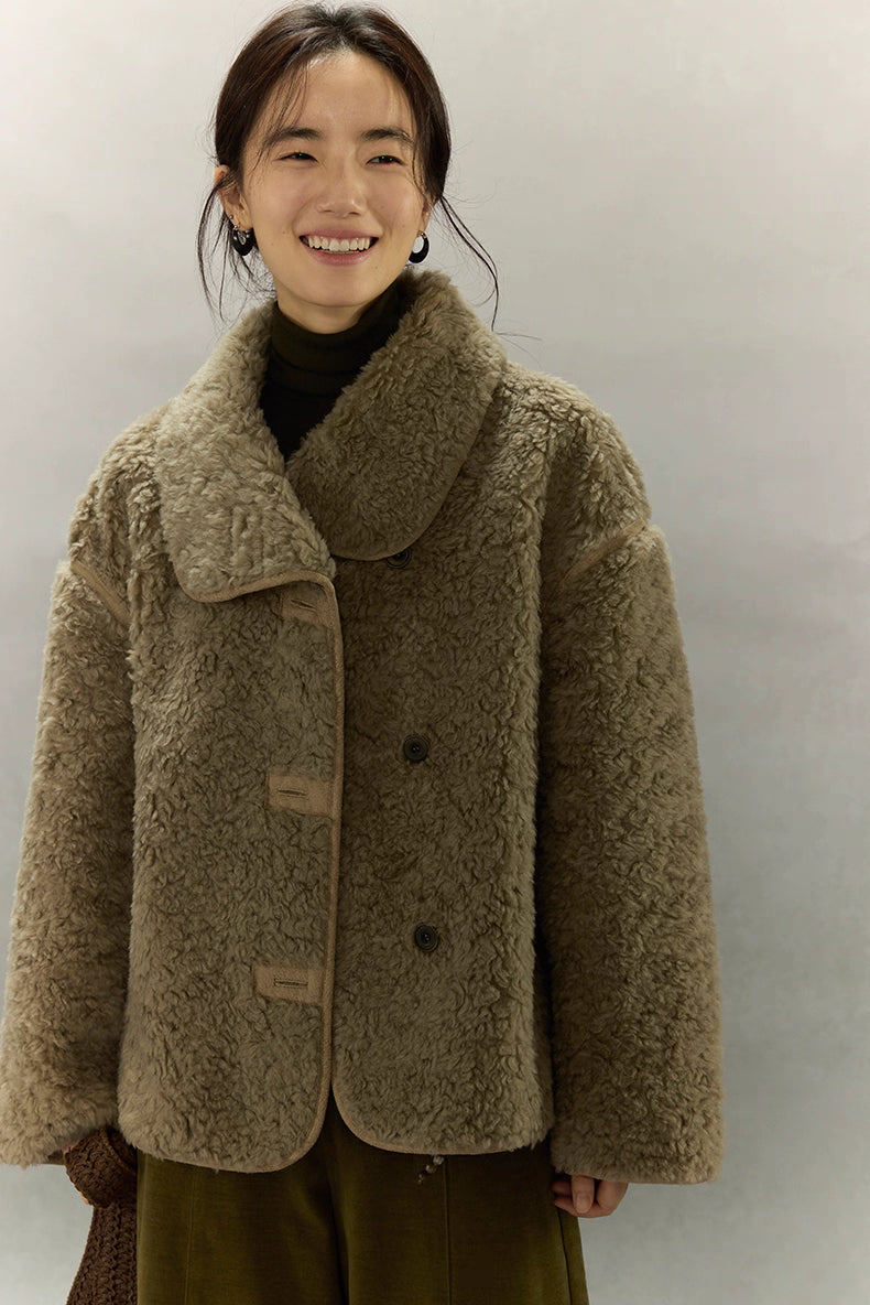 Woman wearing short sherpa wool jacket smiling in front view