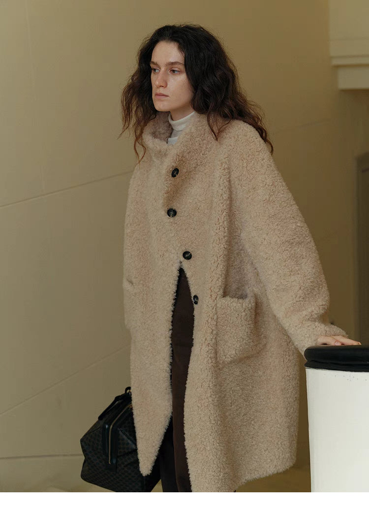 Front relaxed standing view of Sierra Luxe Shearling Coat in beige apricot showing mid-length cut, button closure, and soft textured finish