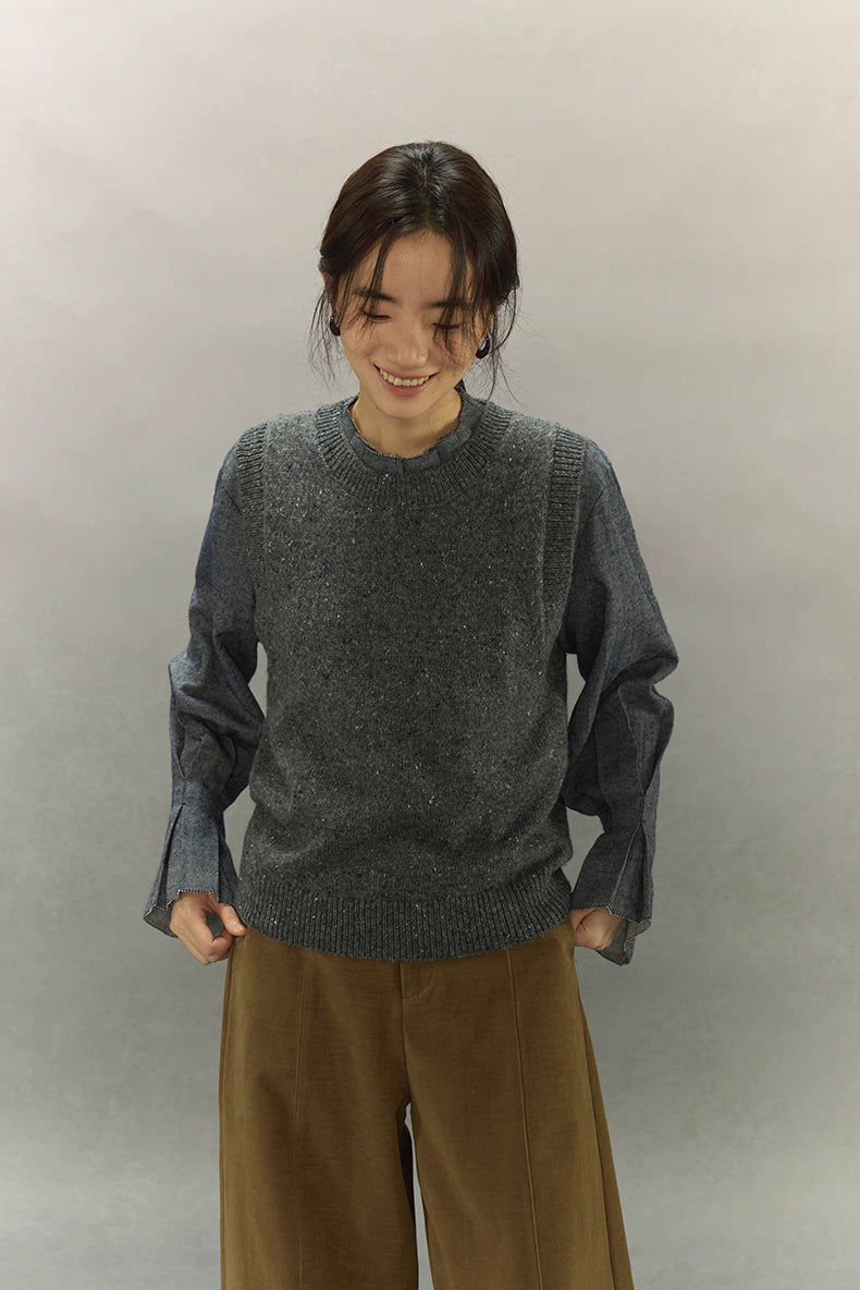 Model smiling in wool-blend speckled vest paired with brown wide-leg pants.