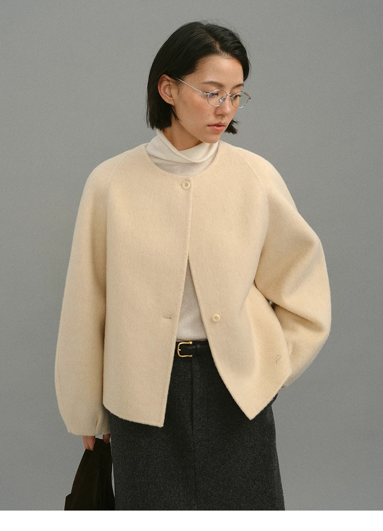 Front view of woman wearing cream soft-wool cocoon jacket with round-neck design