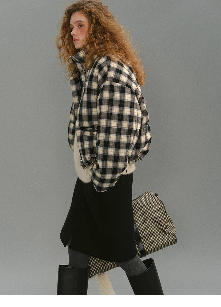 Model walking in the SoftGrid wool check puffer, showing the cropped hem, curved side line, and plaid pattern in motion.
