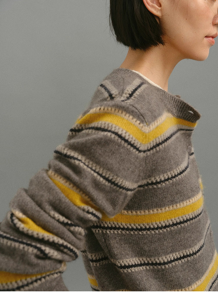 Close-up of the taupe-yellow striped cardigan sleeve and shoulder knit texture, highlighting wool-blend stitches and color detailing.