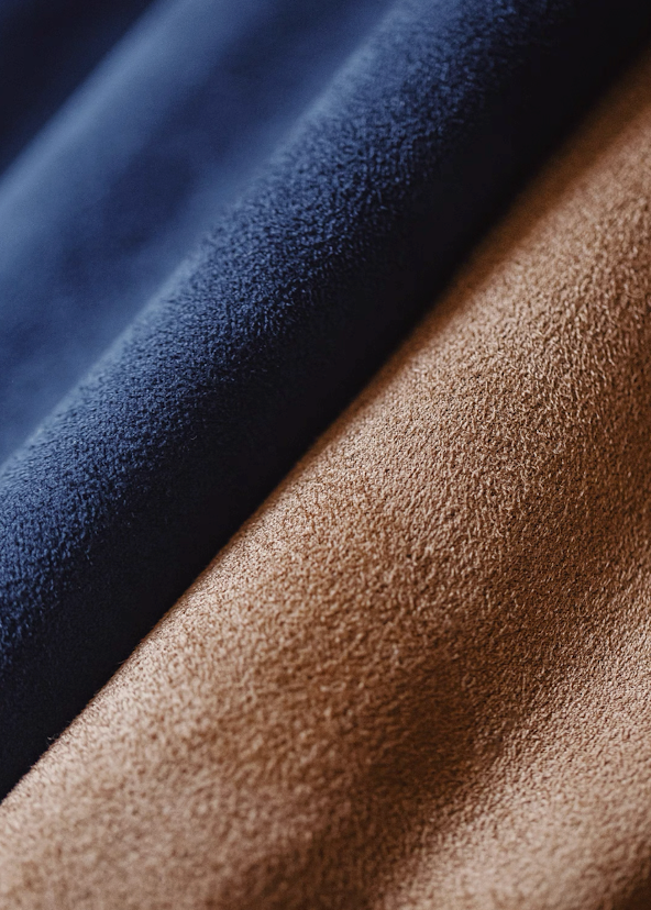 Close-up of soft suede-like fabric in navy blue and camel brown Harrington jacket