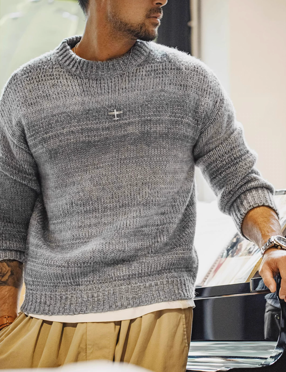 Man wearing Sunset Drift Knit Sweater in Lead Grey featuring gradient ombré knit crewneck design relaxed fit and ribbed hem detail