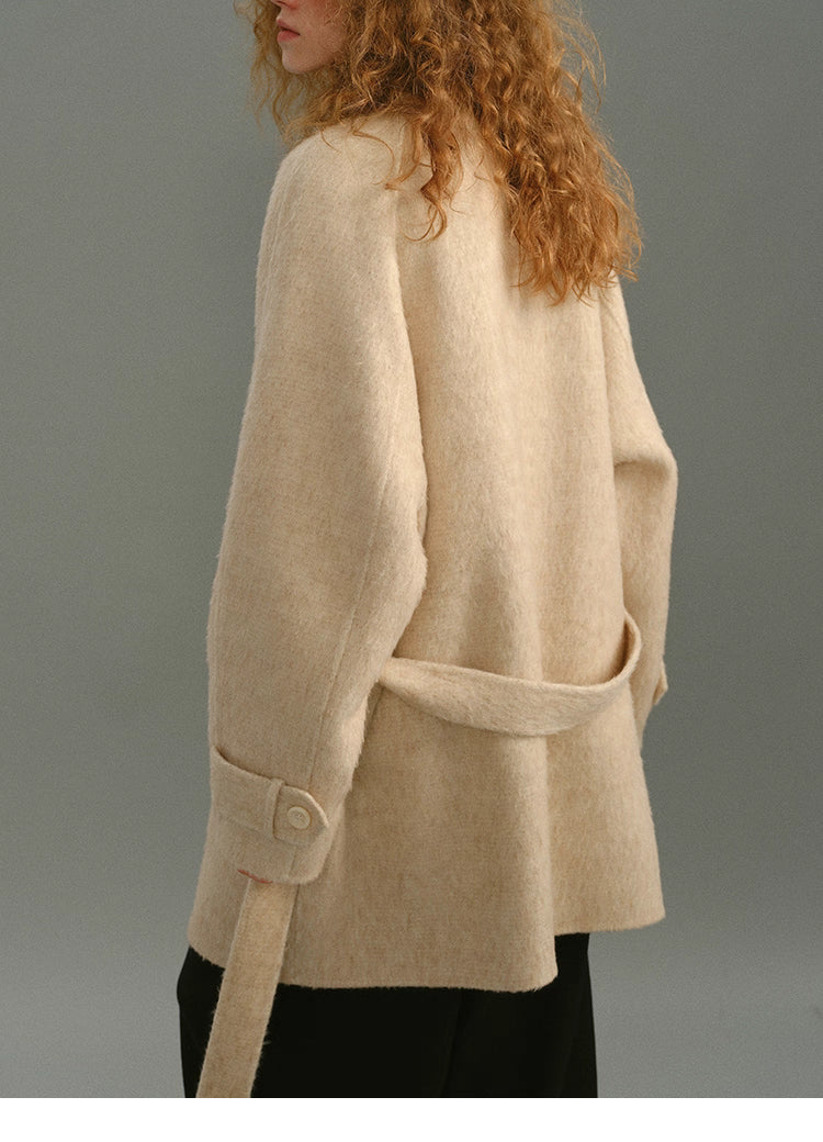Back view showing belt placement and the coat’s soft structured silhouette.