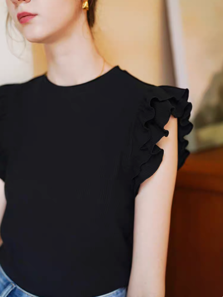 Close-up of black round neck sleeveless top highlighting soft fabric and double-layer ruffle shoulder design