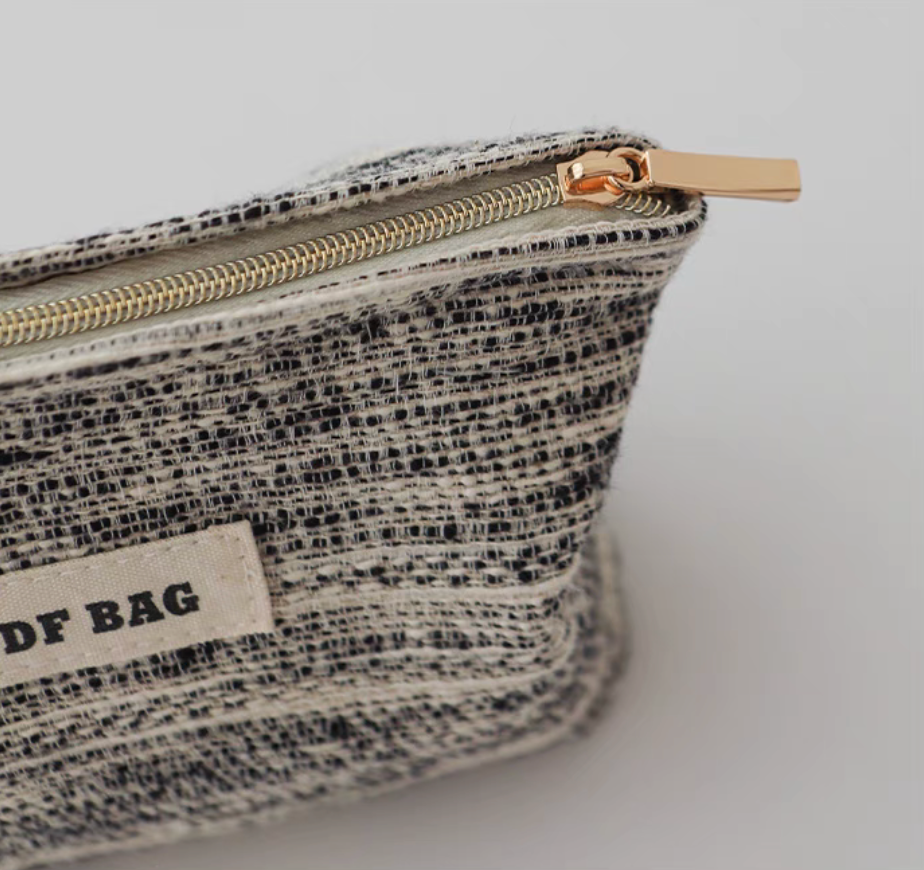 Close-up of Textured Stripe Mini Cosmetic Zip Pouch in stripe pattern featuring textured fabric and gold-tone top zipper