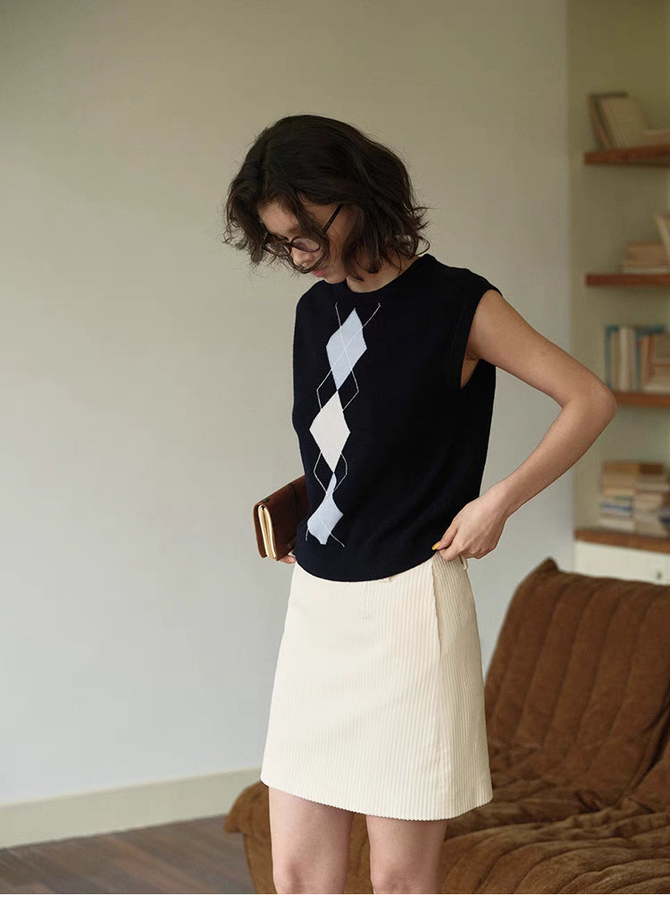 Navy blue Timeless Wool Knit Vest worn casually with white skirt, relaxed outfit showcasing sleeveless wool knit