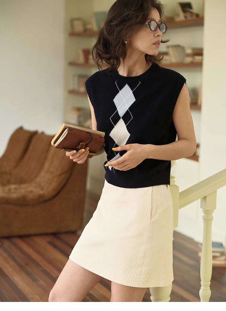 Navy blue Timeless Wool Knit Vest styled with white skirt, lifestyle outfit with preppy argyle knit aesthetic