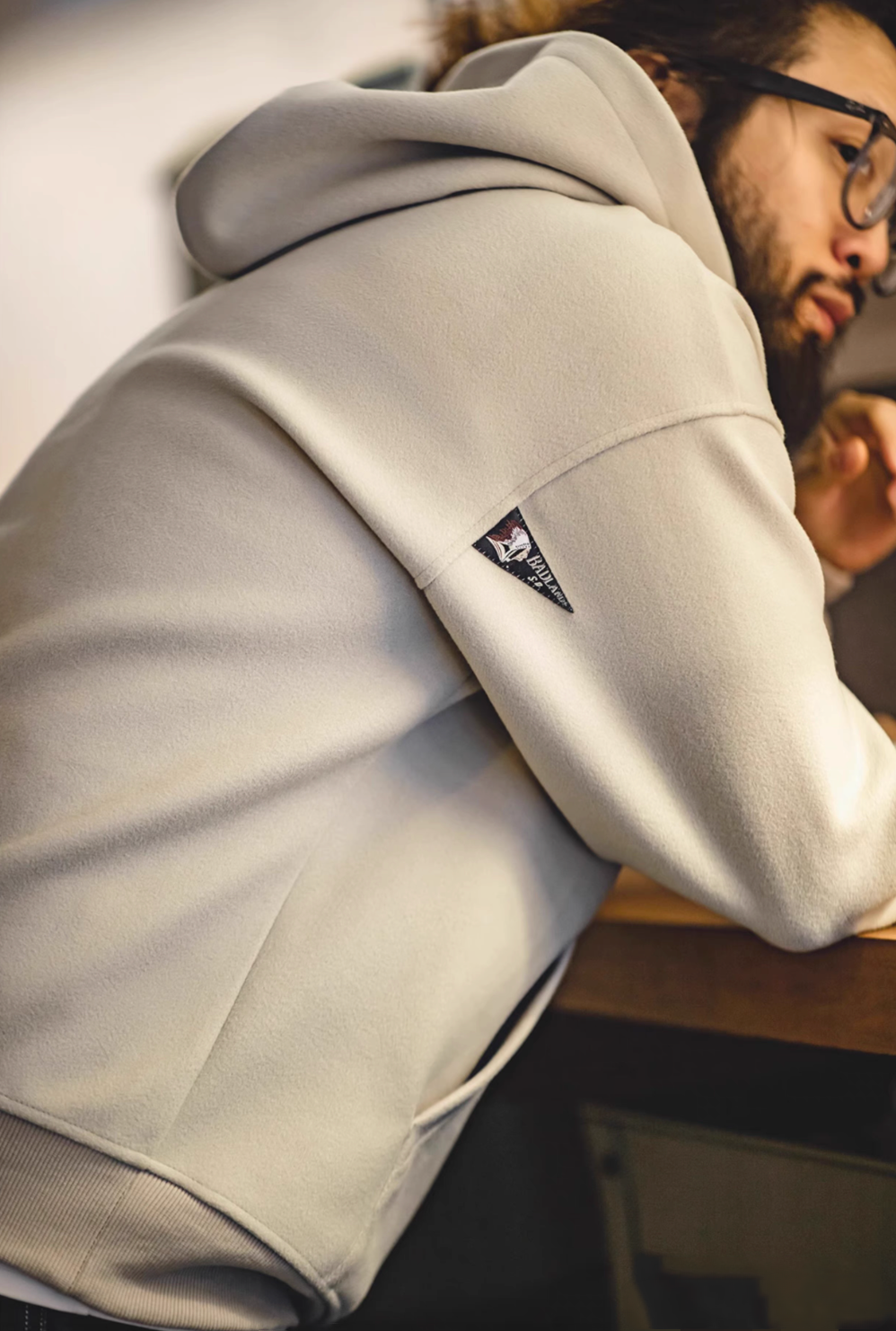 Close-up of Trailblazer Pullover Hoodie in khaki showing side back shoulder and hood with label detail