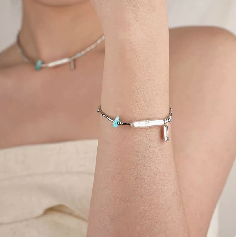 Turquoise baroque pearl bracelet worn on wrist with natural freshwater pearl and silver chain elegant minimalist look