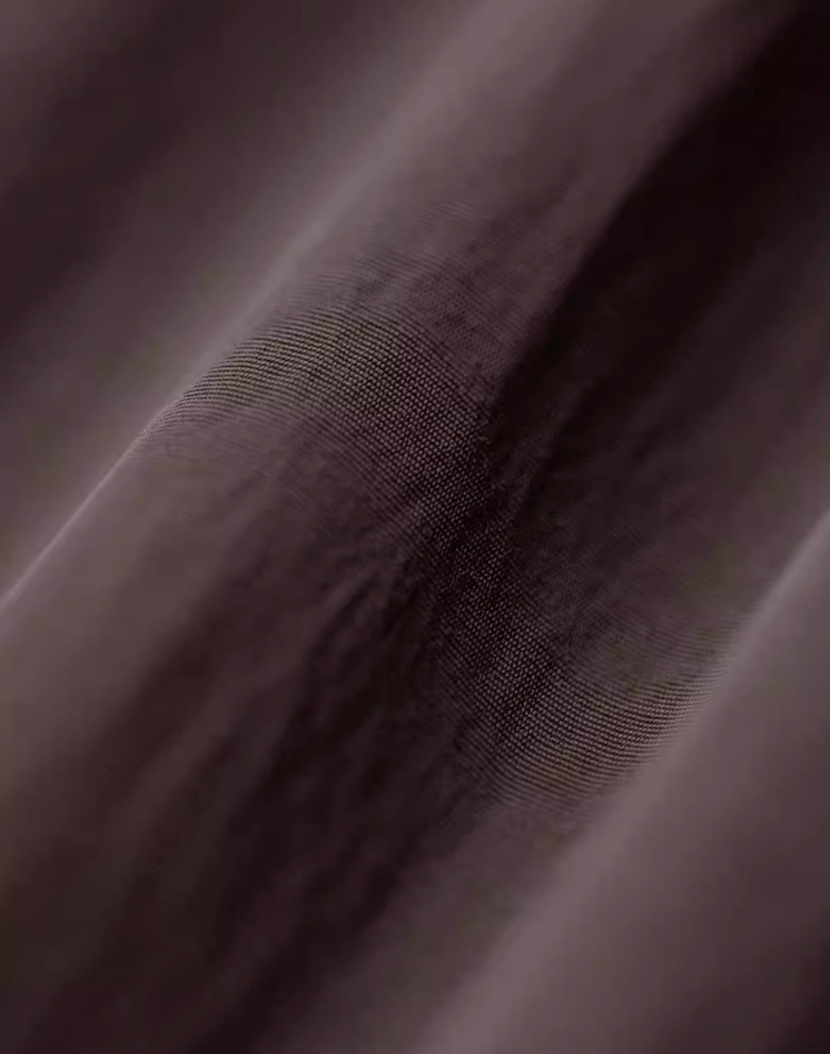 Close-up of crinkle-texture nylon fabric in dark coffee brown color showing subtle sheen and durable weave detail.