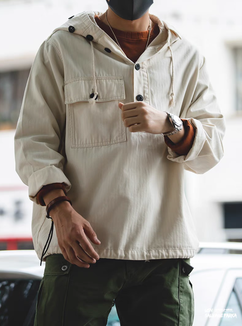 Man wearing Off-White Utility Pocket Hooded Pullover Jacket outdoors showcasing hooded design, utility pocket, and relaxed silhouette