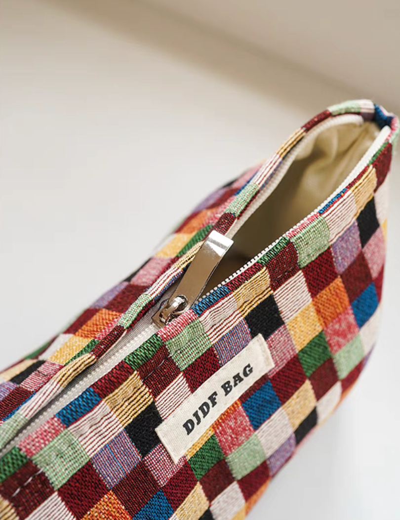 Close-up of small Vibrant Checkered Travel Makeup Bag in multi-colored checkered pattern showing zipper and fabric texture detail