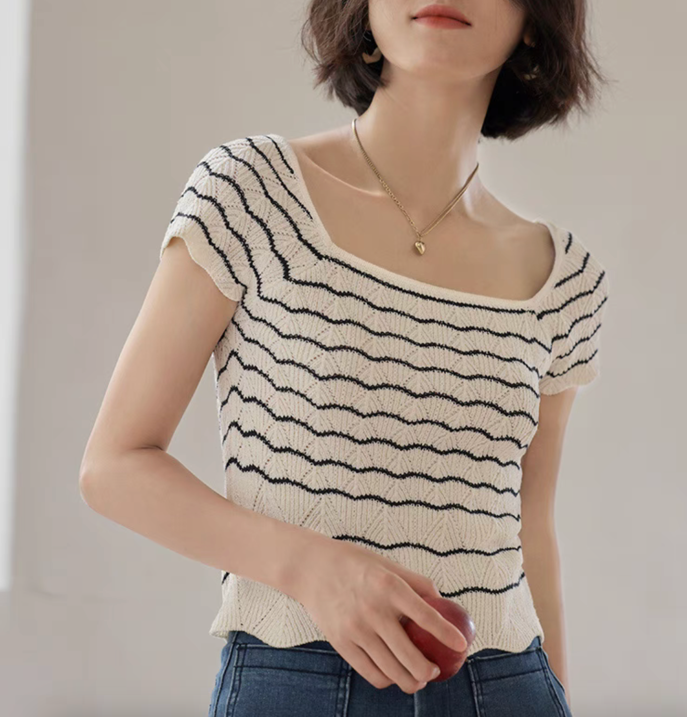 Close-up of black and white striped knit top highlighting openwork texture and soft stretch fabric detail