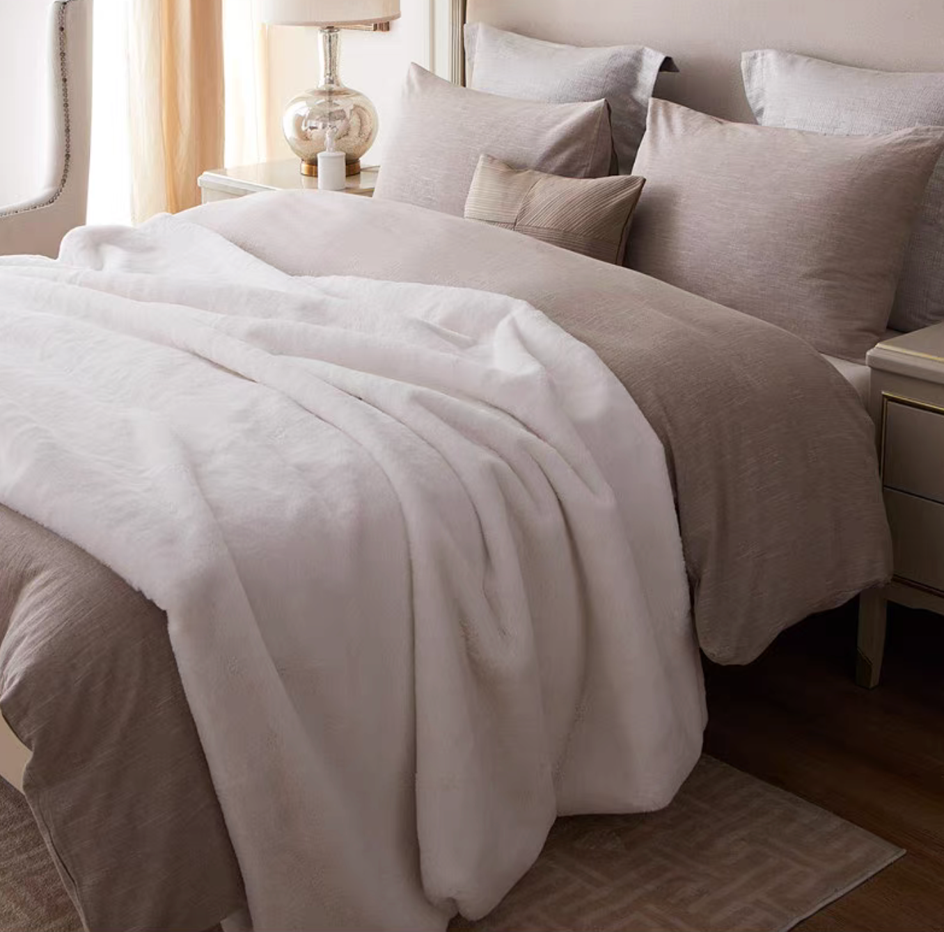 White faux fur throw blanket styled on bed creating a clean soft and luxurious bedroom feel