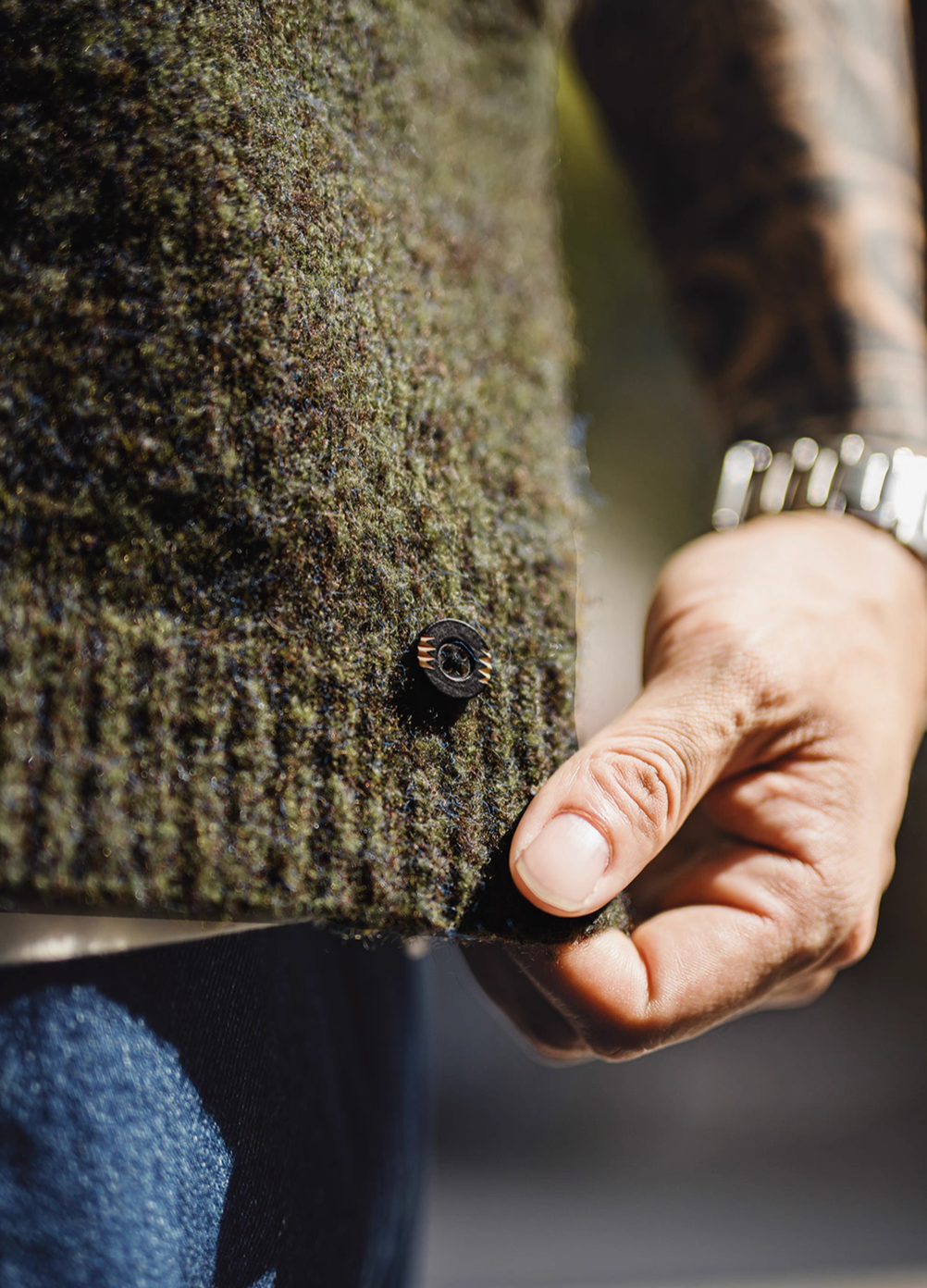 Close-up detail of Woodland Retro V-Neck Vest in Moss Green showing textured knit fabric and hem button detail