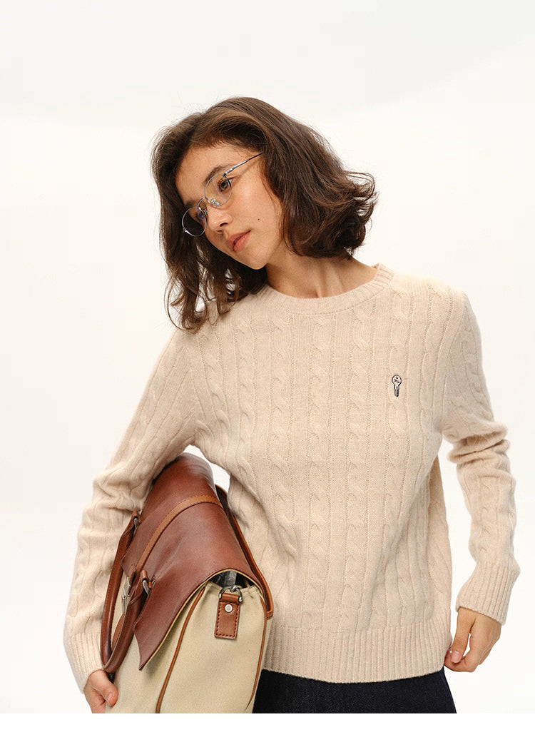 Model wearing beige almond wool sweater holding a canvas-leather bag