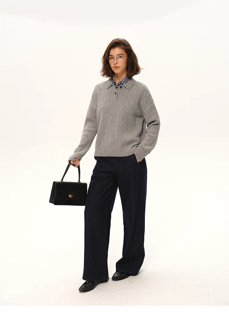 Model wearing grey cable-knit wool polo sweater styled with dark wide-leg trousers