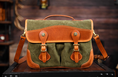 Front view of olive green waxed canvas satchel with tan leather trim and brass buckles