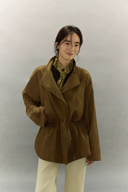 Model wearing caramel brown suede utility jacket with draped lapel front.