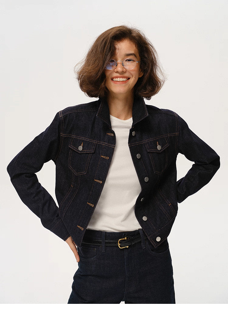 woman wearing dark indigo cropped denim jacket standing with hands on hips