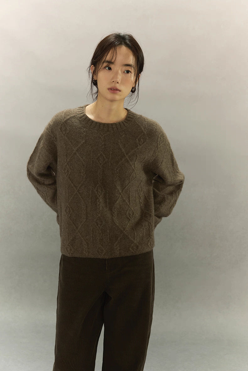 Model wearing warm brown yak wool diamond knit sweater, front view showing textured pattern.