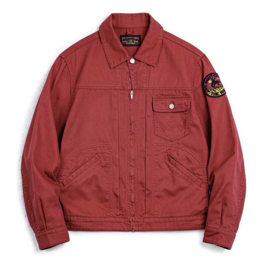 lat lay of men’s rust red rodeo jacket showing patch and front pockets