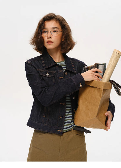 woman wearing dark indigo cropped denim jacket standing with hands on hips