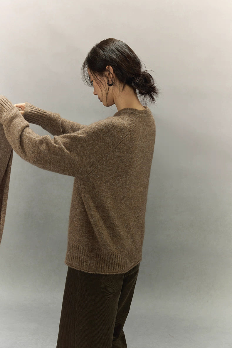 Side profile of model in brown wool cashmere sweater showing soft knit texture and drop-shoulder fit.