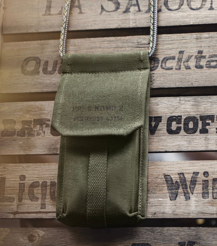 Close-up of vintage olive canvas M-16 Field Pouch Mini on wooden surface