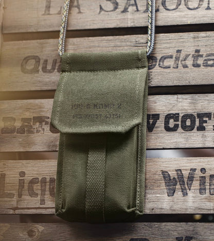 Close-up of vintage olive canvas M-16 Field Pouch Mini on wooden surface