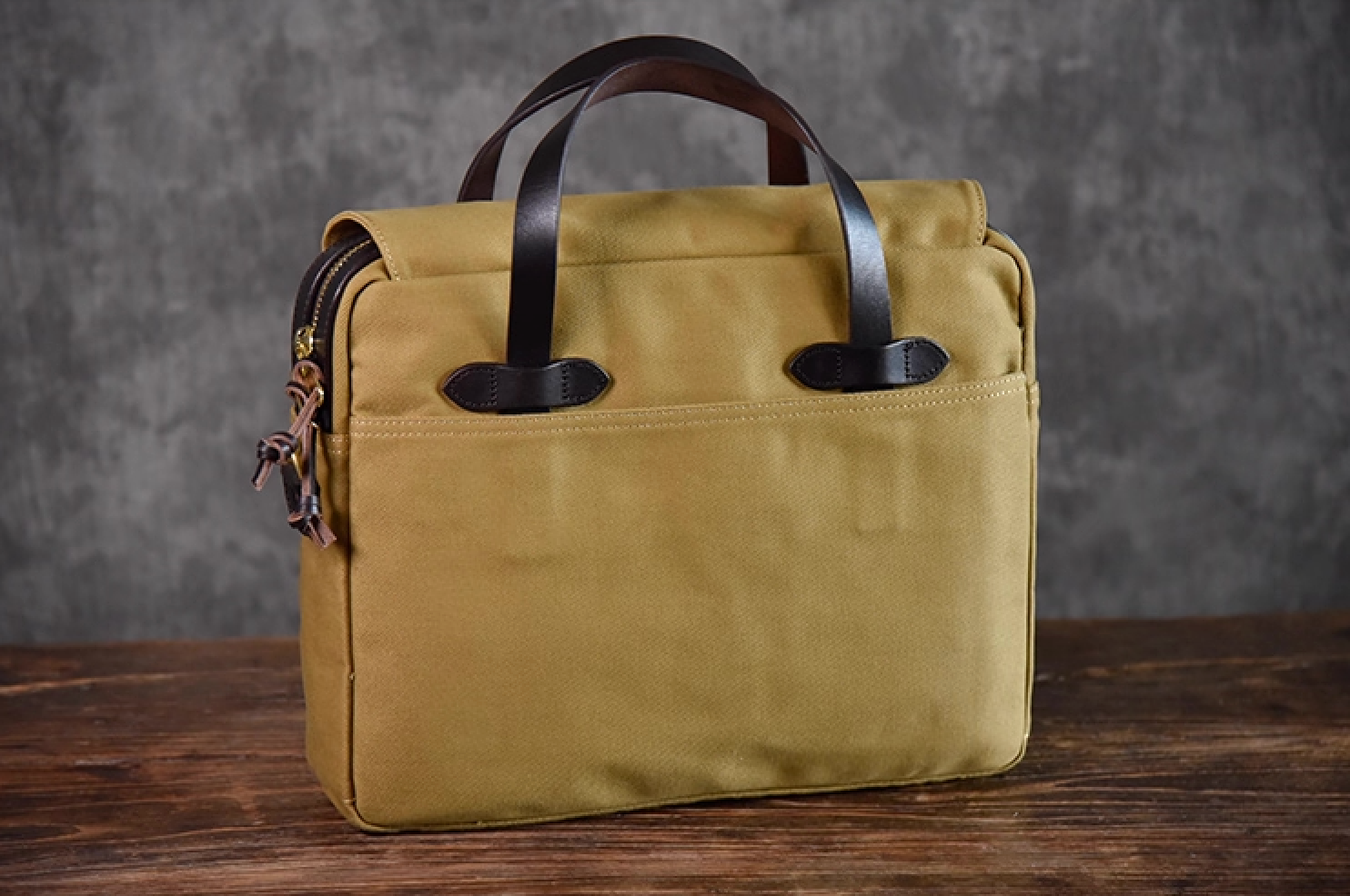 Front view of khaki waxed canvas briefcase with full-grain leather handles