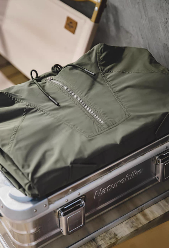 Folded M43 parka on aluminum trunk showing lightweight shell texture
