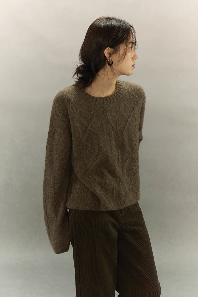 Woman turning sideways in brown yak wool sweater with detailed textured knit pattern.