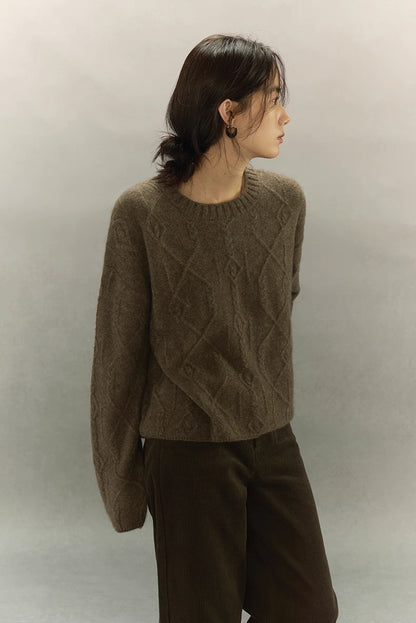 Woman turning sideways in brown yak wool sweater with detailed textured knit pattern.
