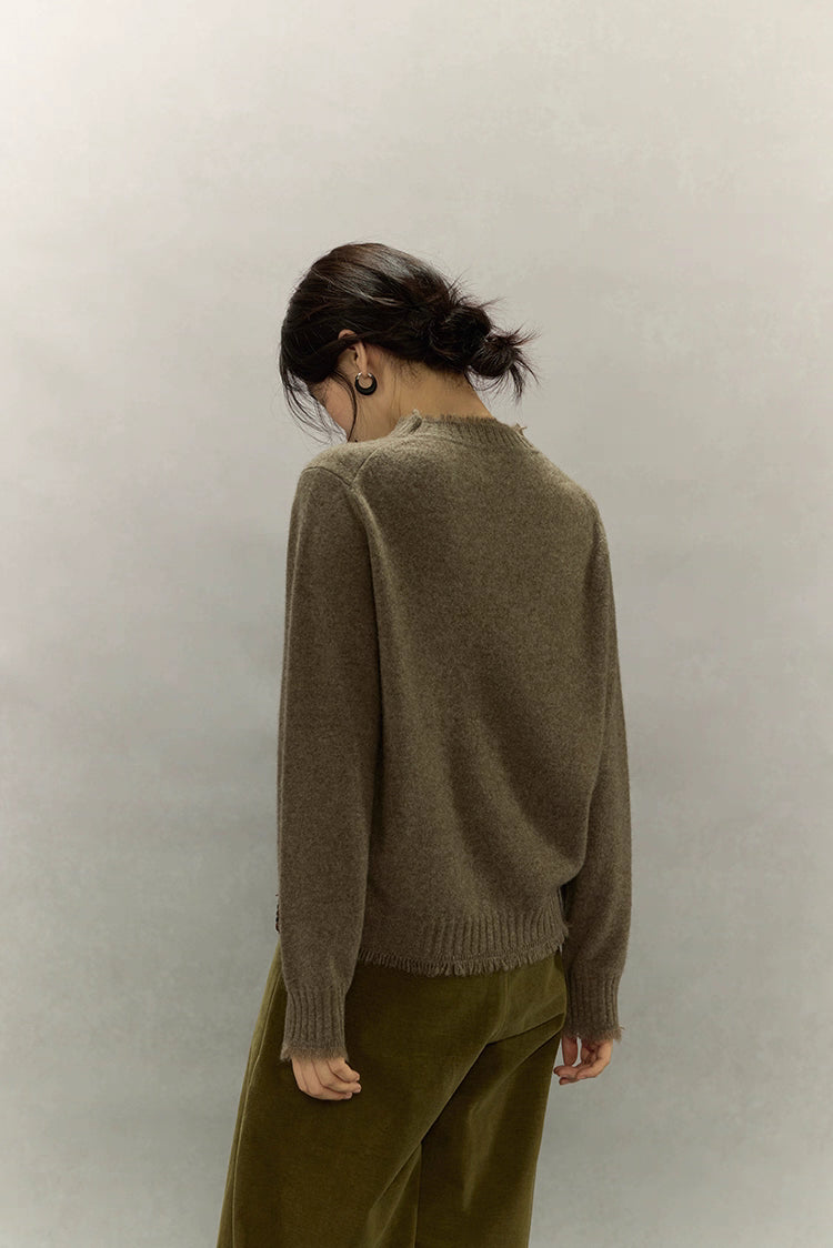 Back view of light coffee brown yak wool sweater highlighting hand-finished fringe edge.