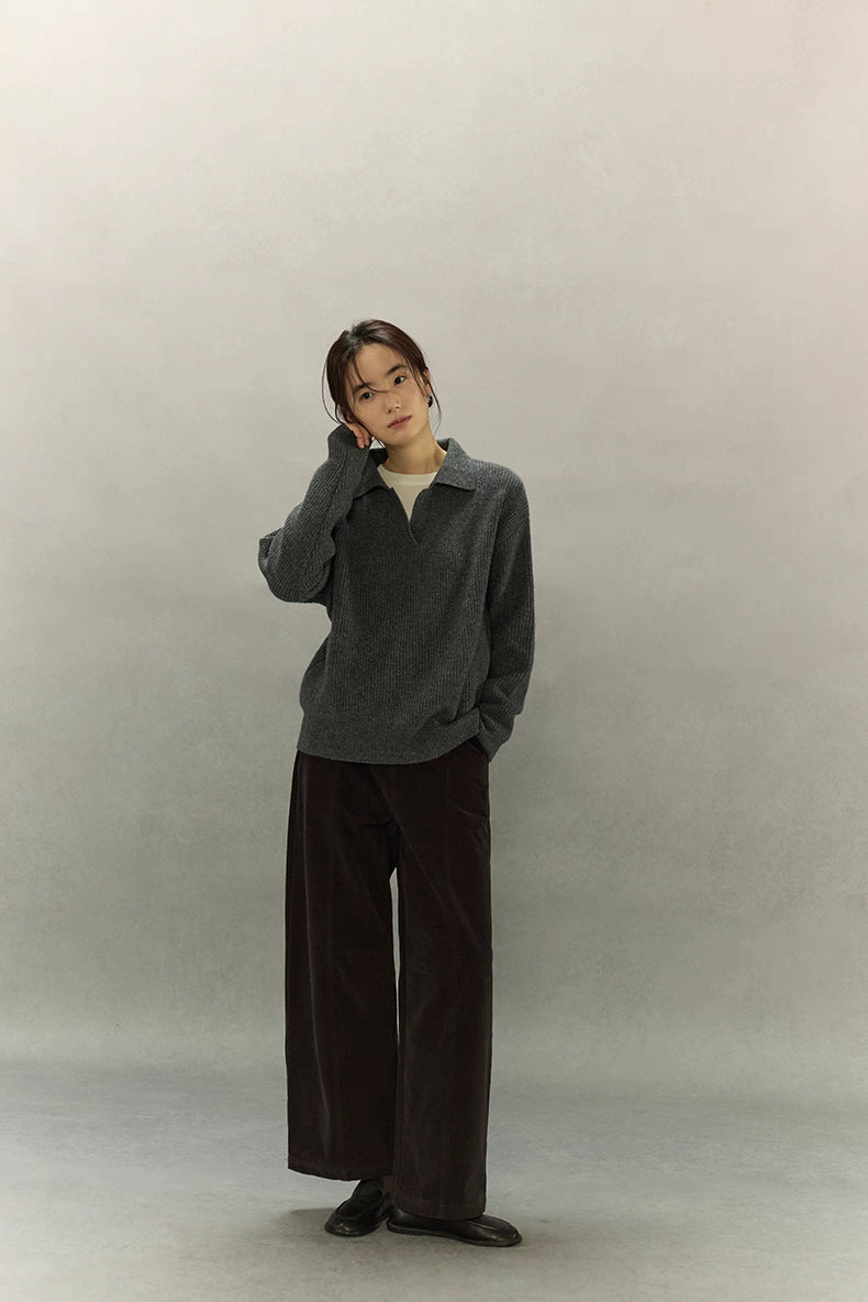 Full-body view of woman wearing relaxed charcoal ribbed sweater and wide-leg pants.