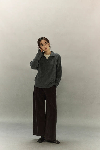 Full-body view of woman wearing relaxed charcoal ribbed sweater and wide-leg pants.