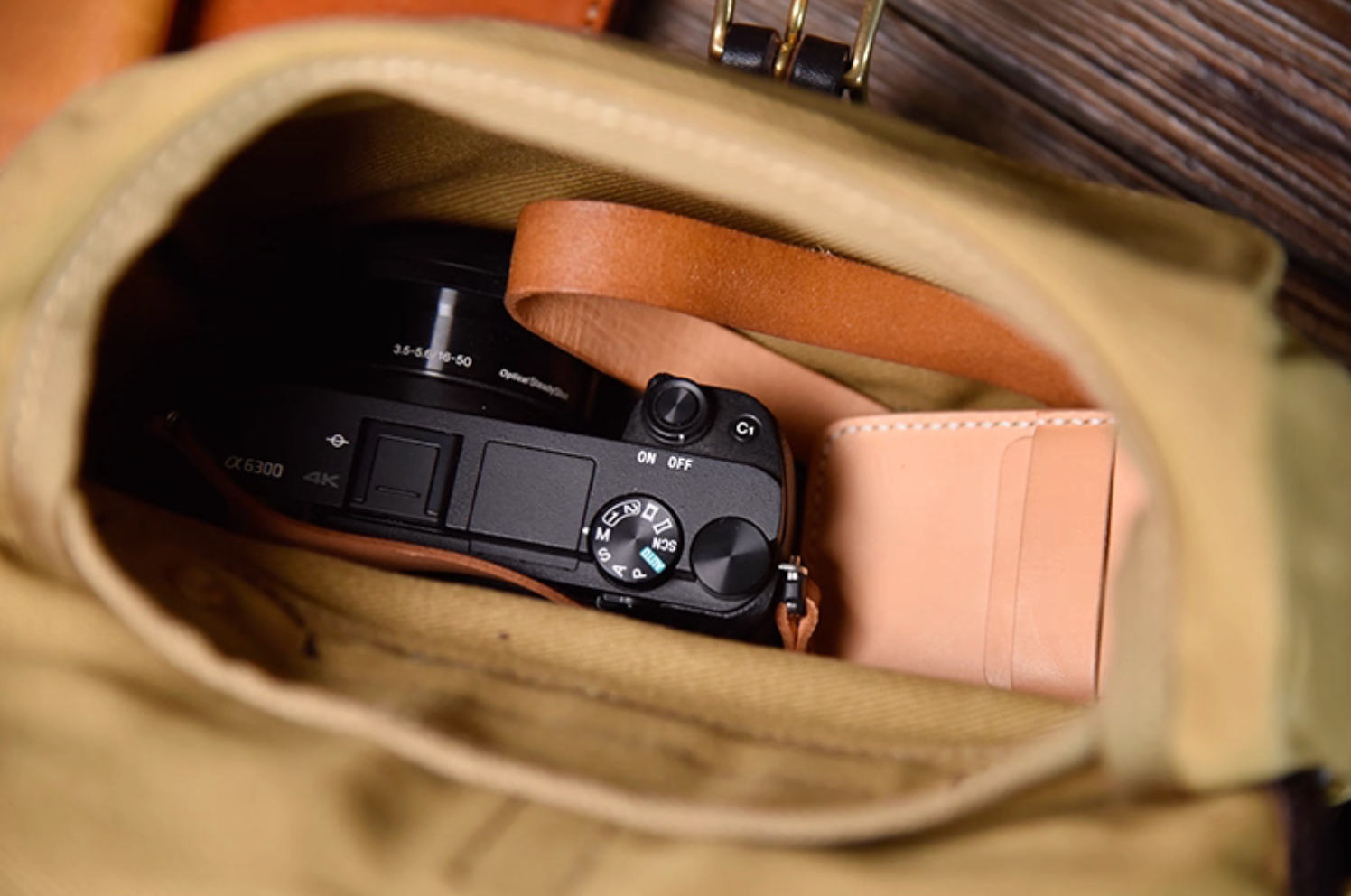 Interior of Nomad Field Tan satchel with camera and wallet inside main compartment.