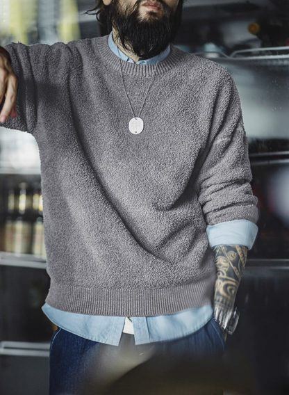 Man in light grey textured sweater styled with denim and shirt underneath