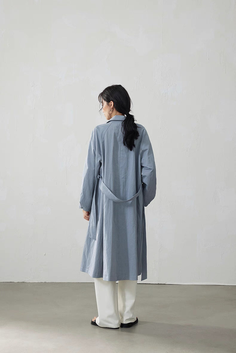 Back view showing adjustable belt and flowing A-line shape of trench coat.
