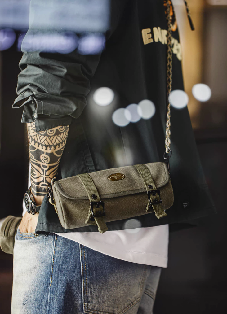 Model wearing olive tool roll crossbody bag with paracord strap over casual outfit